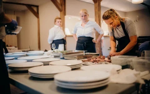 Restaurant kitchen team working together during food preparation